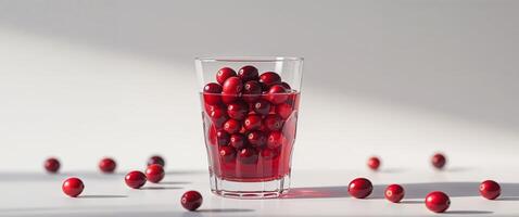 Glass of cranberry juice with fresh cranberries floating inside photo