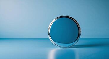 Reflective Surface of a Round Compact Mirror on a Blue Background. photo