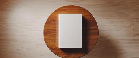 Flat lay of a white book mockup on a warm wooden table with a cozy ambiance. photo