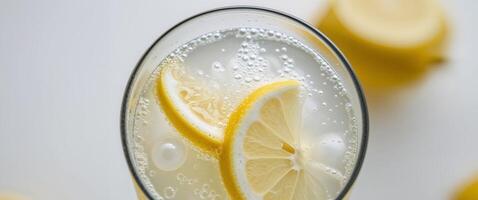 A glass of lemonade with a slice of lemon in it photo