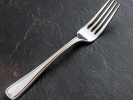 Elegant silver fork on a dark stone surface photo
