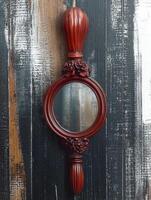 Vintage hand mirror with a wooden frame and handle photo