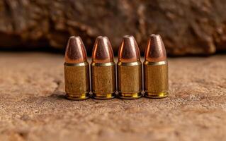 Ammunition lined up on a textured surface. photo