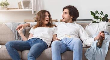 Shocked Couple Waking Up In Messy Room After Celebration Party At Home, Floor Covered With Garbage And Empty Bottles photo