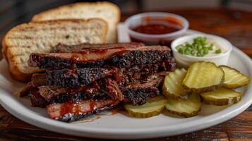 Succulent slices of smoked brisket served alongside dill pickles, tangy barbecue sauce, ranch dressing, and toasted bread, creating a hearty barbecue meal experience. photo