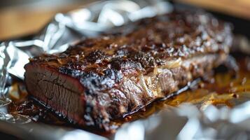 Juicy beef brisket glistens with a rich glaze, resting on foil in a backyard setting as warm sunlight adds a golden hue to the scene during a late afternoon gathering. photo