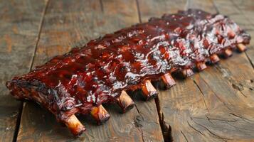 Deliciously cooked barbecue ribs coated in savory sauce are placed on a rustic wooden table, inviting to enjoy during a summer gathering or family meal. photo