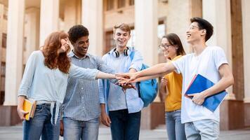 Students Unity. Group Of Diverse Millennials Holding Hands Standing In Circle Outside University Building. photo