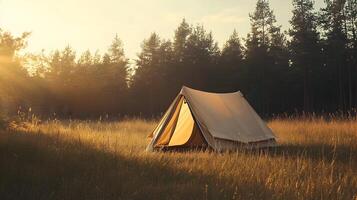 Peaceful camping scene with a tent in a field illuminated by the warm golden light photo