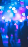 Crowd Silhouettes Immersed in a Dazzling Display of Blue and Violet Bokeh Lights photo