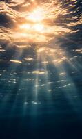 Underwater sun rays shining through the ocean surface, creating ethereal beauty and light photo