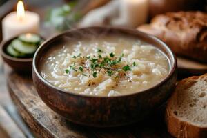 Steaming french onion soup with parsley and pepper in rustic bowl garnished with sliced cucumbers and bread photo