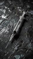 Syringe laying on dark background representing drug addiction issues photo