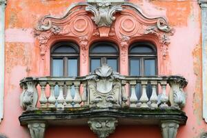 Weathered balcony with balusters and windows showing rococo style architecture photo