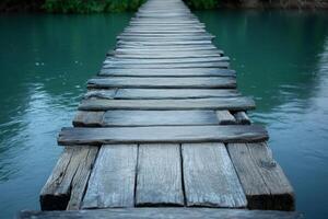 Old wooden bridge crossing a river with turquoise water photo