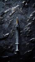 Syringe laying on dark rock background representing drug addiction issues photo