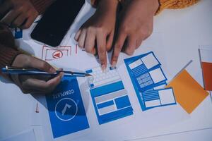 Hands on a table with various web design items photo