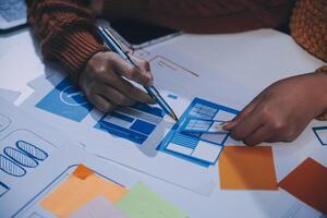 A person is working on a design project with a pen photo
