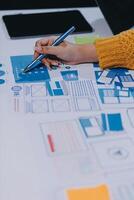 A person is working on a design project with a pen and paper photo