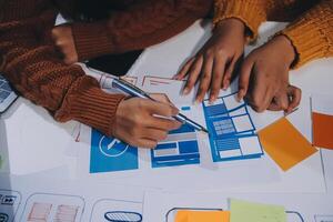 Two people working on a project with paper and pens photo