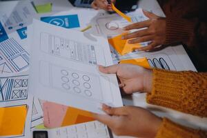 A group of people working on a project with paper and pens photo
