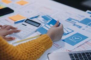 A woman is working on a spreadsheet with a calculator photo