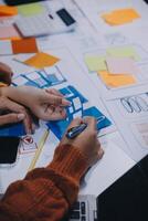 A group of people working on a project with paper and pens photo