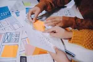 Two people working on a project with paper and sticky notes photo