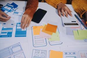 A group of people working on a project with paper and pens photo