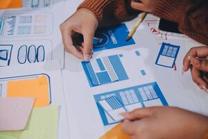 A person is working on a design project with a paper and pencil photo
