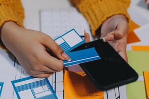 A person is holding a cell phone with a business card on it photo