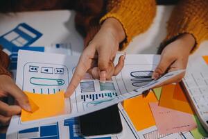 Two people are working on a project with paper and pencils photo