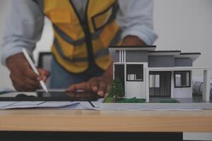 A man is working on a model of a house photo