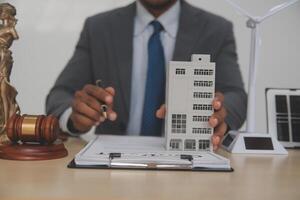 A man in a suit is holding a model of a house photo