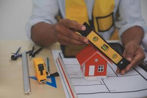 A man is holding a model of a house on a table photo
