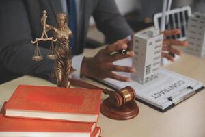 Lawyer in office with books and statue of justice photo