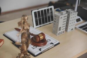 Lawyer's desk with a gavel, a book, a laptop, and a solar panel photo