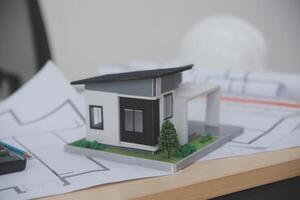 A model of a house on a desk with a calculator photo