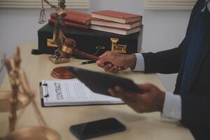 Lawyer holding a gavel and tablet in front of a desk photo