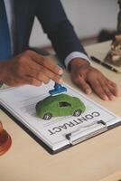 A man signing a contract with a green car photo