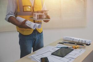 A man holding a blueprint and a tablet computer photo