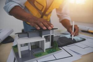 A man is working on a model of a house photo