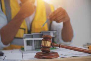 Construction worker with gavel and model of house photo