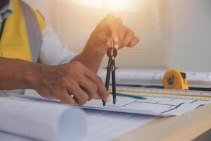 A man is working on a blueprint with a ruler photo