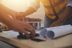 Two people working on a model of a house photo
