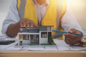 A man is working on a model of a house photo