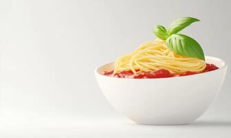 A bowl of spaghetti with red sauce and a green leaf on top photo