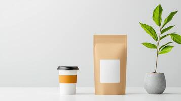 A coffee cup and a bag of coffee sit on a table next to a potted plant photo