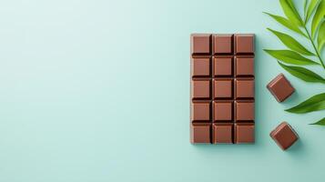A chocolate bar is on a table with a green leaf photo