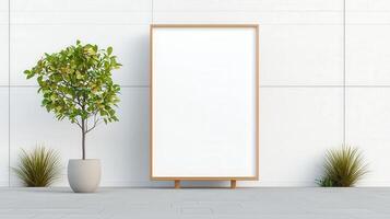 A white framed picture sits on a white wall next to a potted plant photo